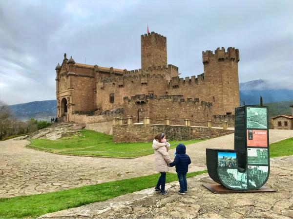 Dos niños al lado de una J delante del Castillo de Javier